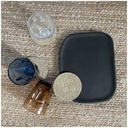 Plateau Osmose ovale en bois noir présenté avec des verres colorés et des dessous de verre sur une surface texturée - Dakar, Sénégal
