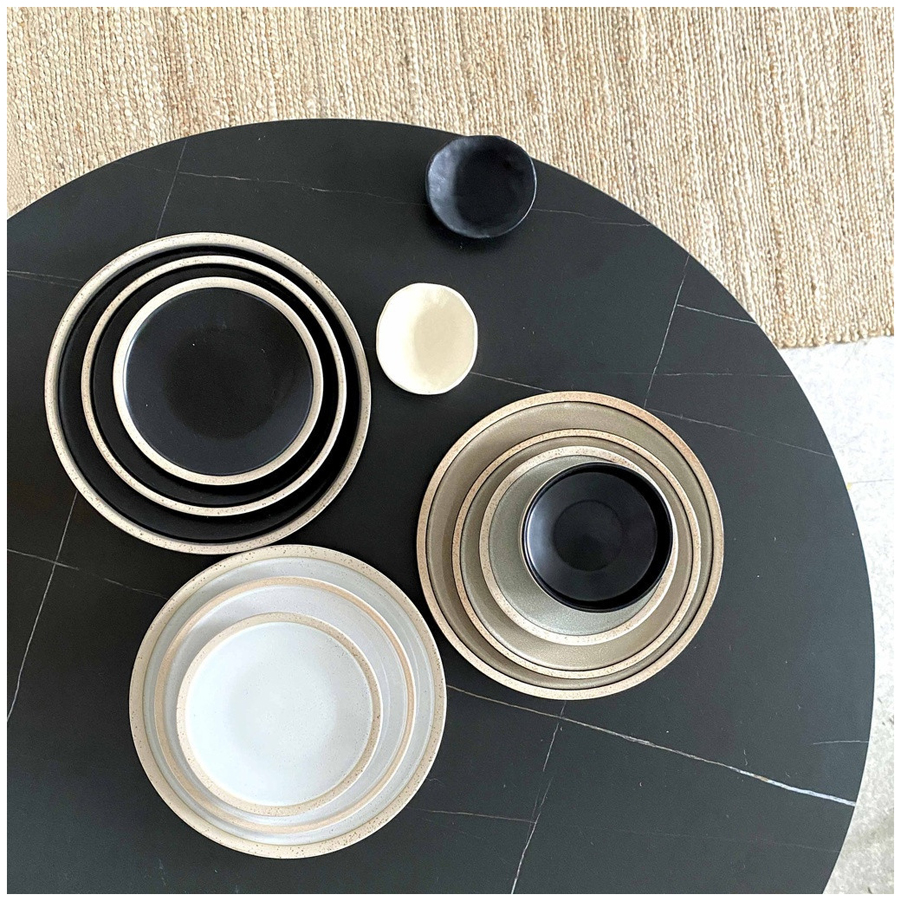 Service de vaisselle Wabi en grès sable et noir, disposé sur une table noire avec un style contemporain - Dakar, Sénégal"
