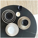 Collection Wabi en grès sable, comprenant des assiettes plates et des coupelles, présentée sur une table moderne - Dakar, Sénégal
