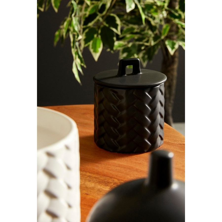 Bougie Twine avec couverture en céramique noire sur une table en bois, Dakar, Sénégal.