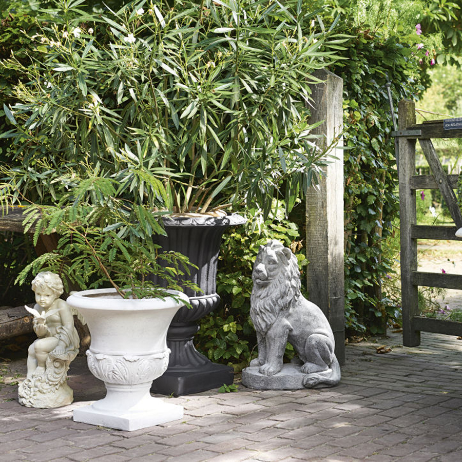 Coupe de jardin Eyguières en résine gris anthracite utilisée comme décoration extérieure parmi des plantes et des statues dans un jardin à Dakar, Sénégal.