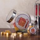 Deux bocDeux bocaux en verre KUB, grand et petit modèles, posés sur une table avec des cubes de bouillon dorés - Dakar, Sénégal.