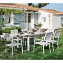 Ensemble de table et fauteuils Portofino en aluminium blanc dans un jardin fleuri près d'une maison à Dakar, Sénégal.
